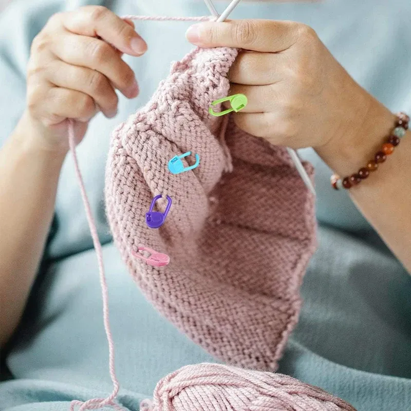Knitting in progress with locking stitch markers clipped into the fabric
