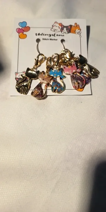 Enamel charm stitch markers photographed by a verified buyer